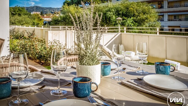 An outdoor dining area with tables set for two, complete with wine glasses, plates, and cutlery. - Cosy Beach | Beach - pool - terrace (Marbella)