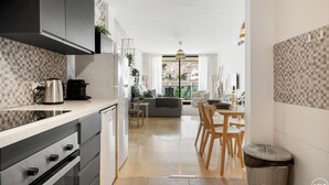 Eine moderne Küche mit Essbereich und Blick auf die Stadt, inklusive Mülleimer.
