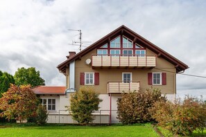 Et toetagers hus med rødt tag, balkon og parabolantenne.