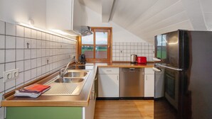 A modern kitchen with a stainless steel refrigerator, a dishwasher, and a wooden countertop.