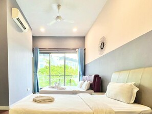 Une chambre d’hôtel avec deux lits, un ventilateur de plafond et une vue sur la verdure environnante.