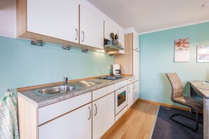 Una cocina con un fregadero, estufa y armarios.