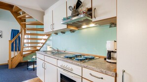 A kitchen with a wooden staircase, a built-in oven, and a coffee maker. - Apartment 'Bi Reiner' with Private Terrace and Wi-Fi (Nordstrand)
