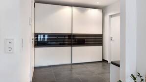 Eine moderne Küche mit schwarzem Arbeitsplatz, weißen Schränken und einem gefliesten Boden.