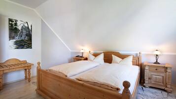 Una camera da letto con un letto di legno, due comodini, una scrivania in legno e un quadro appeso al muro.