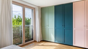 A room with a sliding glass door to a balcony, a bed, and a set of cabinets. - Apartment 'Schambachhof' (Bötzingen am Kaiserstuhl)