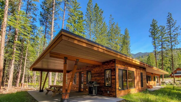A wooden cabin with a covered porch, a barbecue grill, and a picnic table. - Petrichor - Mazama Modern Cabin (Mazama)