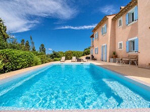 A swimming pool with lounge chairs and a building with blue shutters. - Villa with views, pool, and close to the beach (Cavalaire sur Mer)