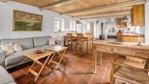 Un salon chaleureux avec un canapé, une table basse en bois et un tableau accroché au mur.
