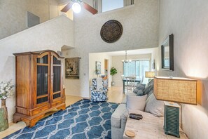 A spacious living room with a large wooden cabinet, a patterned rug, a sofa, and a lamp. - Convenient St Simons Island Home - 3 Mi to Beach! (St Simons Island)