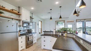 A modern kitchen with white cabinets, stainless steel appliances, and a granite countertop. - Modern Bryan Farmhouse on 1 Acre w/ Hot Tub! (Bryan)