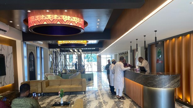 Un hall de hotel con recepción, zona de estar y decoración moderna.