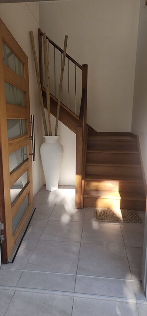A staircase with wooden steps and a handrail, leading to an upper floor. - Starfish Beach House (Agnes Water)