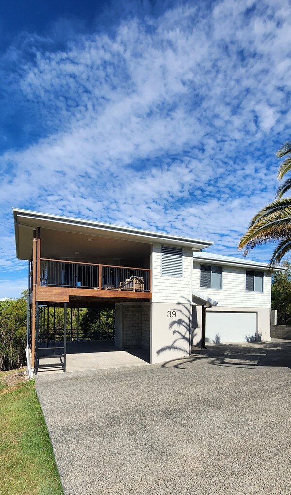 Une maison moderne à deux étages, dotée d’un porche couvert, d’un garage et d’une allée.
