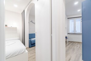 Un dormitorio moderno con cama, un sofá azul y una mesita.
