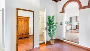 A hallway with a wooden wardrobe, a potted plant, and an archway leading to a room. - GuestHost - Charming 75 sqm apartment, able to accommodate up to 4 people, located on the FOURTH floor of an ancient building (NO lift). The property is located in the historic center of Florence (Restricted Traffic Area), in the lively Sant'Ambrogio dis (Firenze)