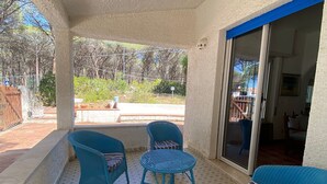 A covered patio with blue wicker furniture, a patterned floor, and a view of the outdoors. - Splendid detached villa, near the sea (Santa Lucia)