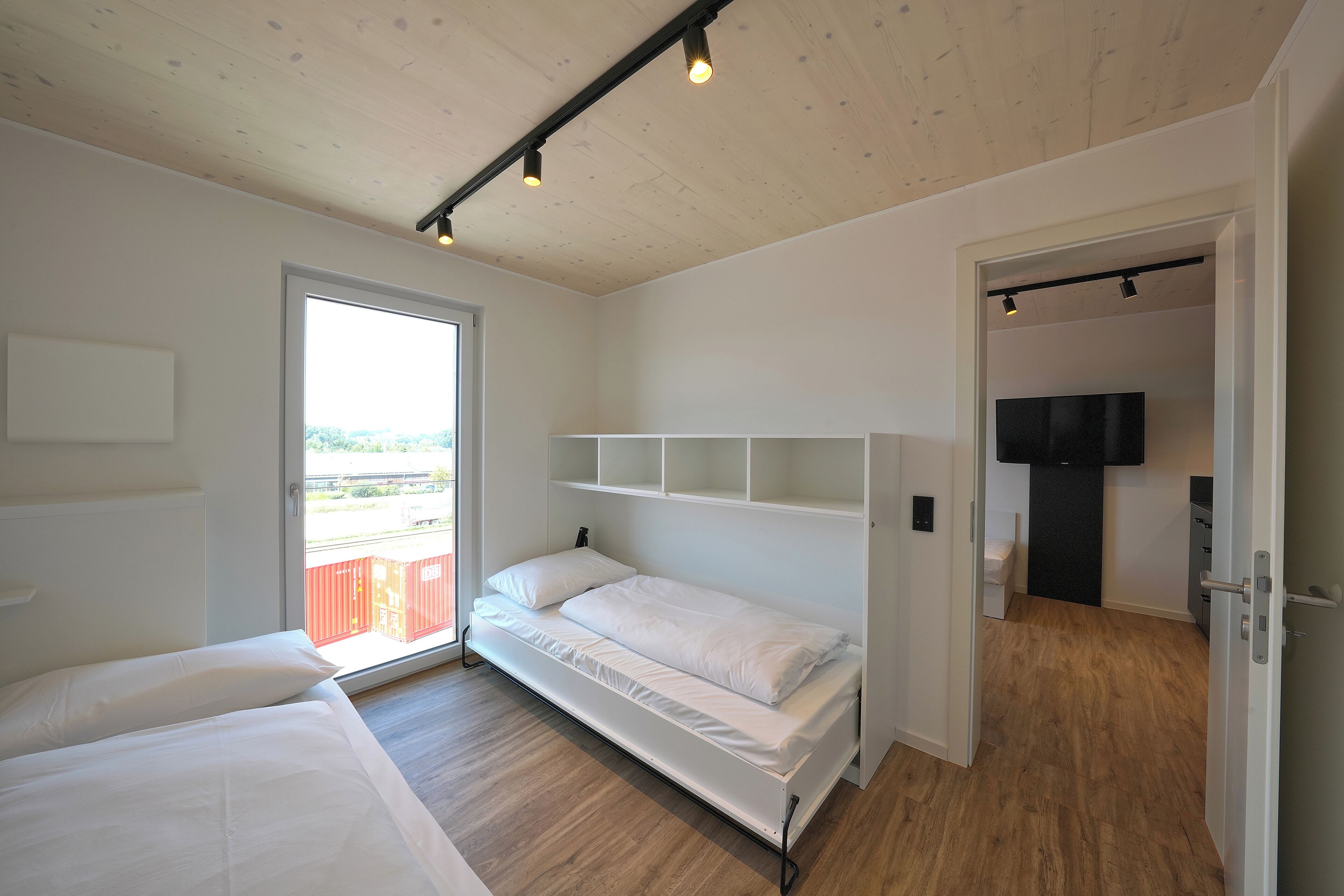 Een slaapkamer met een bed, een televisie en uitzicht.
