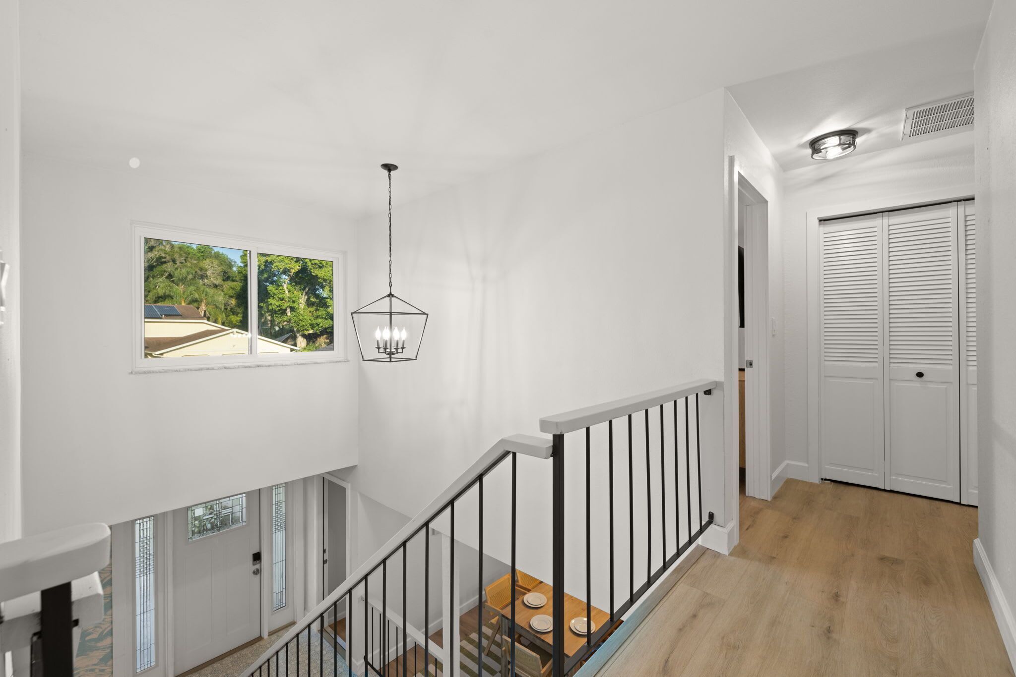 Un interior moderno con una escalera, un comedor y vistas al exterior.