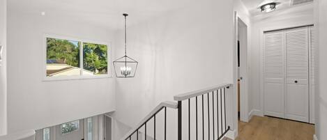 Un interior moderno con una escalera, un comedor y vistas al exterior.