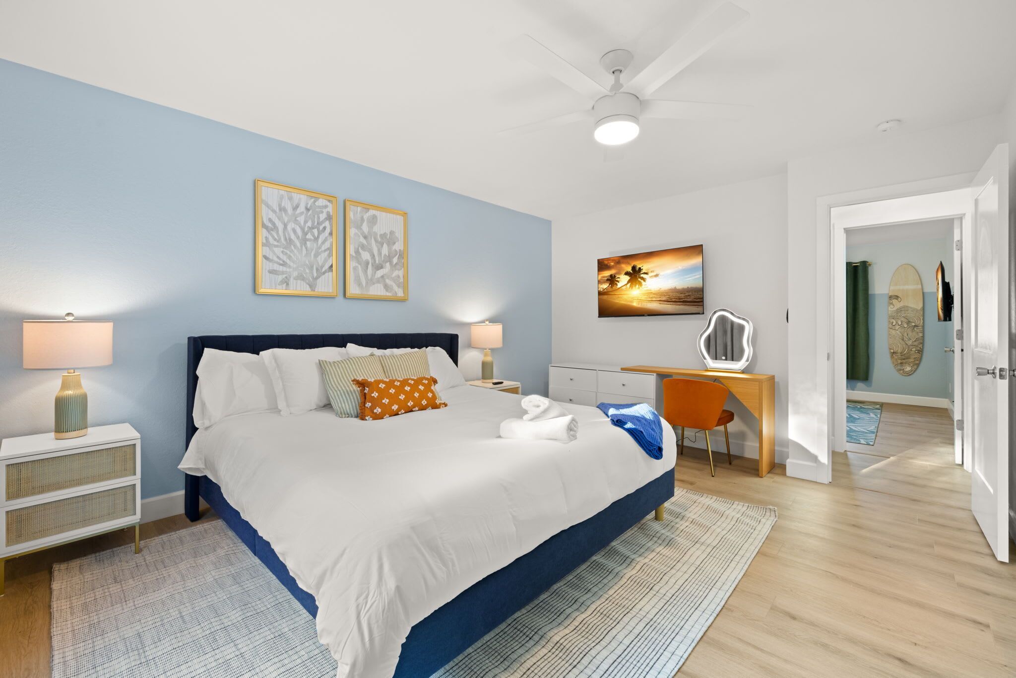 A bedroom with a bed, bedside tables, a desk, and a chair.