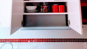 Un meuble de cuisine contenant divers ustensiles et ustensiles de cuisine.