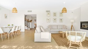 A spacious living room with a dining area, a sofa, and a coffee table. There are two hanging lights and framed pictures on the wall. - Villa Pepponi MENORCA modern, private pool, AC (Sant Lluís)