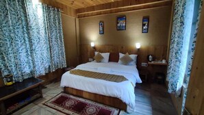 Une pièce en bois avec un lit, des rideaux, une table de chevet et un tapis rouge.