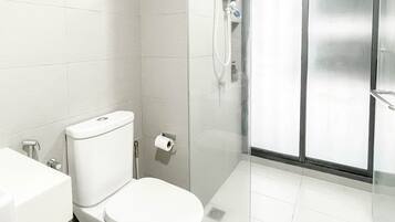 A modern bathroom with a toilet, sink, and glass-enclosed shower.