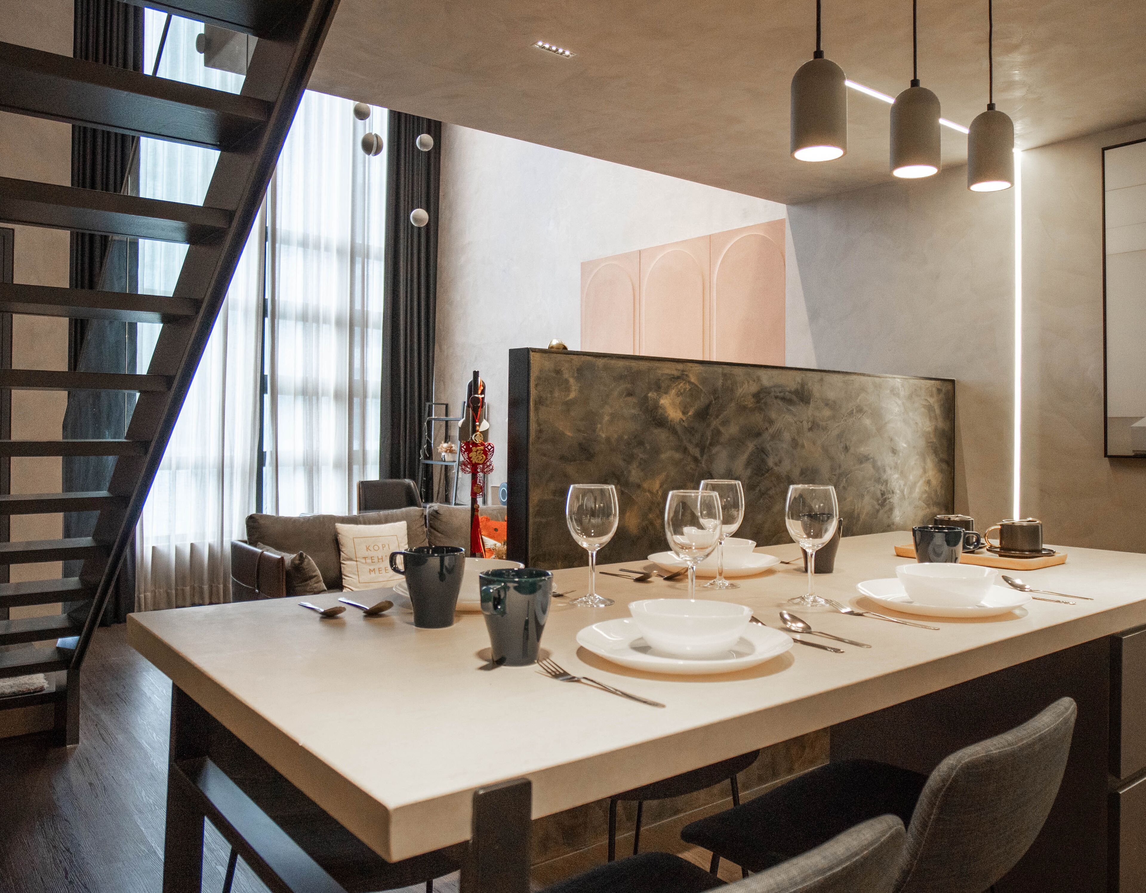 A modern dining area with a long table set for four, featuring a minimalist design with a neutral color palette.