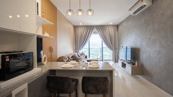 Una cocina moderna con comedor, televisor de pantalla plana y vista a la ciudad.
