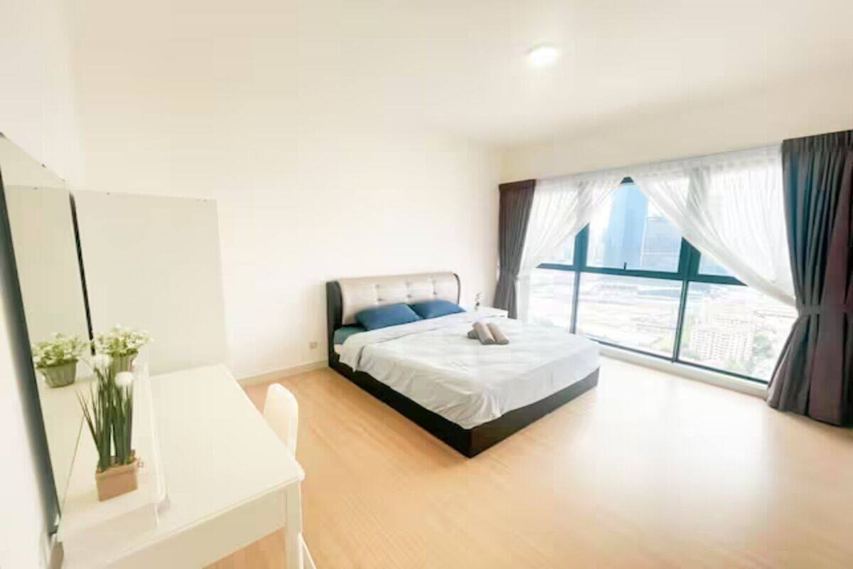 Ein Schlafzimmer mit Bett, Schreibtisch und großem Fenster.