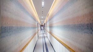 A long, narrow hallway with patterned walls and a tiled floor. - ASAR by Orion Hotels (New Delhi)