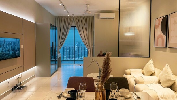 A modern living room with a sofa, a coffee table, and a TV mounted on the wall. - Guestonic Netizen Cozy Studio (Cheras)