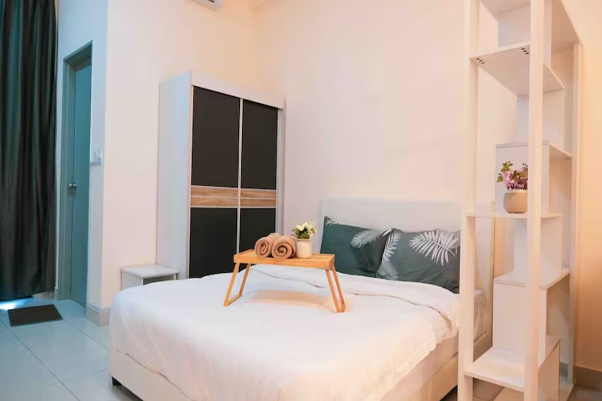 A modern bedroom with a bed, a bedside table, a wardrobe, and a shelf unit.