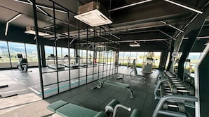 A gym with exercise equipment, large windows, and a view of the outdoors. - Guestonic Netizen Cozy Studio (Cheras)