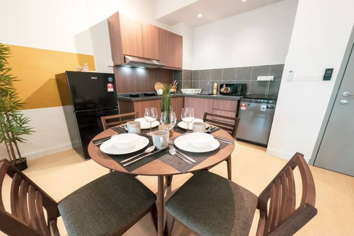 Uma cozinha moderna com uma mesa de jantar para quatro pessoas, equipada com frigorífico, micro-ondas e máquina de lavar loiça.