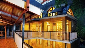 A multi-story wooden house with a balcony and a covered porch. - Virman Riverside Resort (Banjar)
