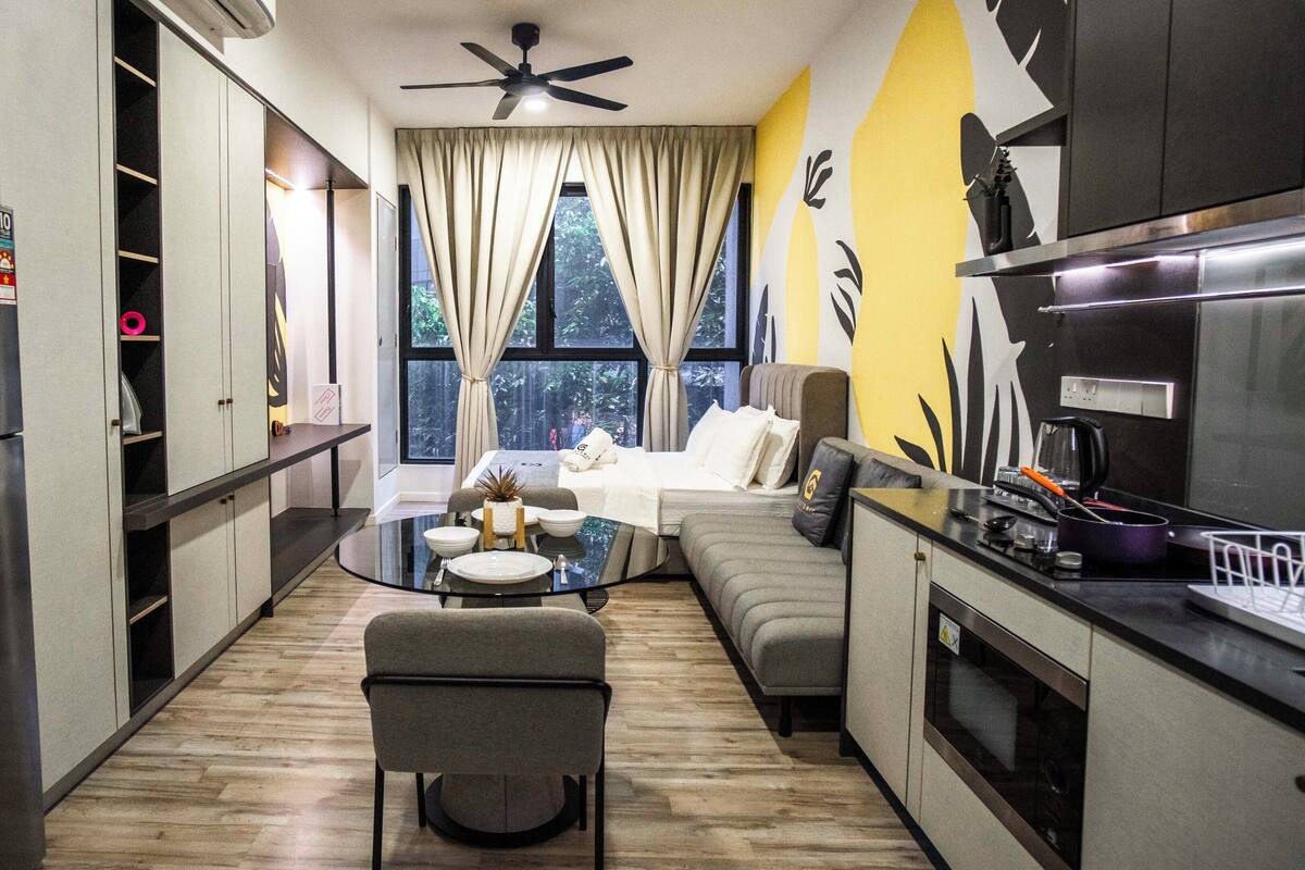 Una cocina compacta con comedor, sofá y ventilador de techo.