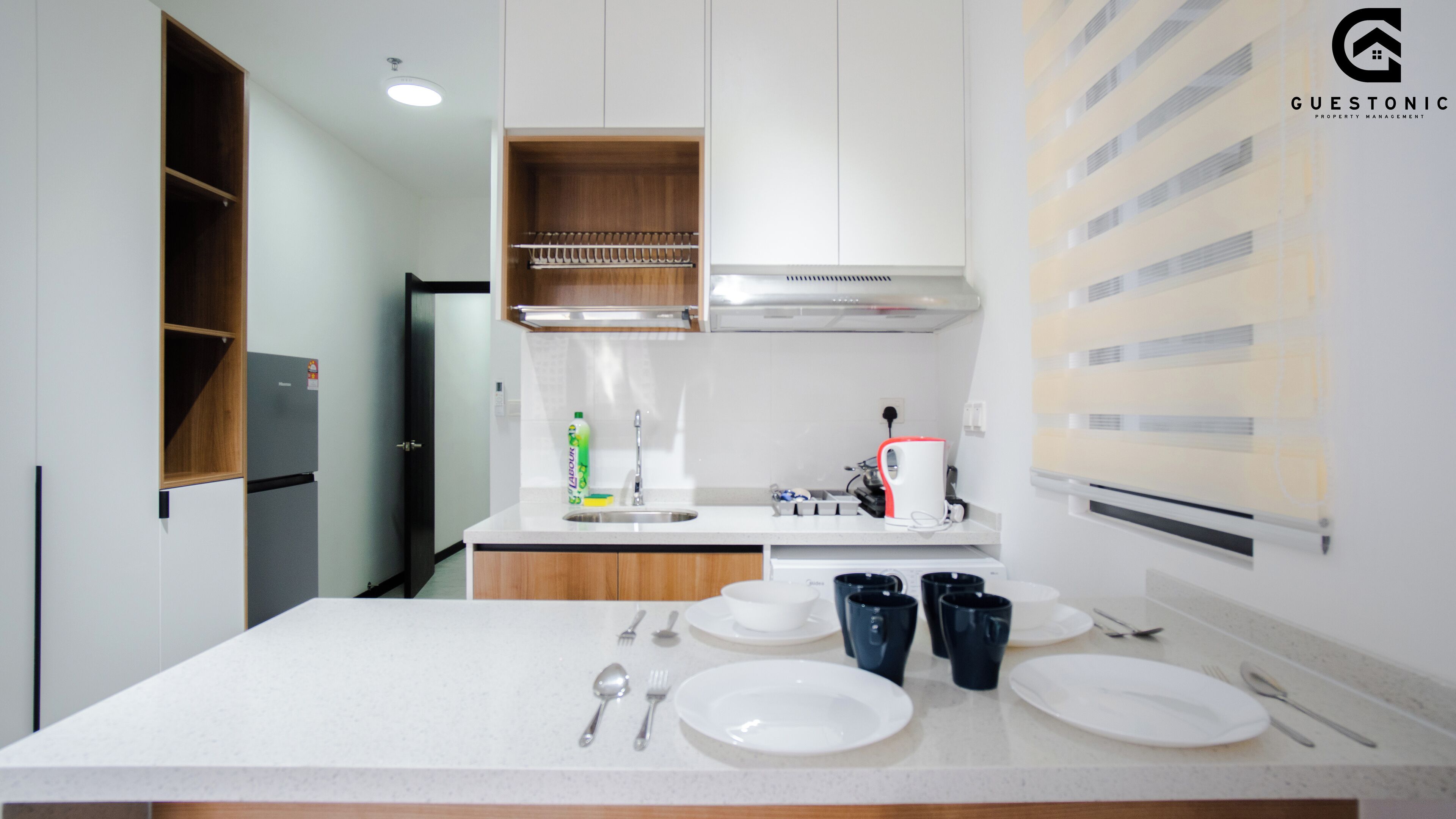 A modern kitchen with white countertops, wooden cabinets, and a built-in oven.