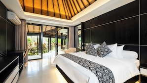 A modern bedroom with a large bed, a TV, and a ceiling fan. - Villa Kubu Dewi Sri by Villa Finder (Canggu)