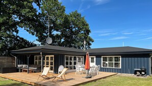 A house with a covered patio, outdoor furniture, and a satellite dish.