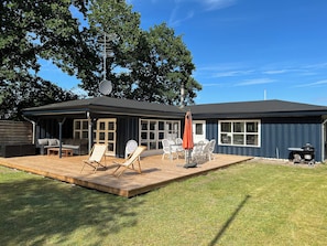 A house with a covered patio, outdoor furniture, and a satellite dish. - Charming summer house on a secluded plot (Glesborg)