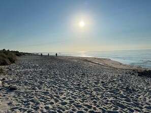 A beach with footprints, a clear sky, and the sun low on the horizon. - Charming summer house on a secluded plot (Glesborg)
