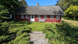 A red house with a white door and windows, surrounded by greenery. - Cozy country estate in Vesterborg. (Vesterborg)