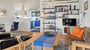 Un soggiorno moderno con zona pranzo, cucina e libreria.