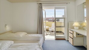 Une chambre d’hôtel avec un lit, un bureau doté d’une lampe, une chaise et une vue sur l’extérieur.