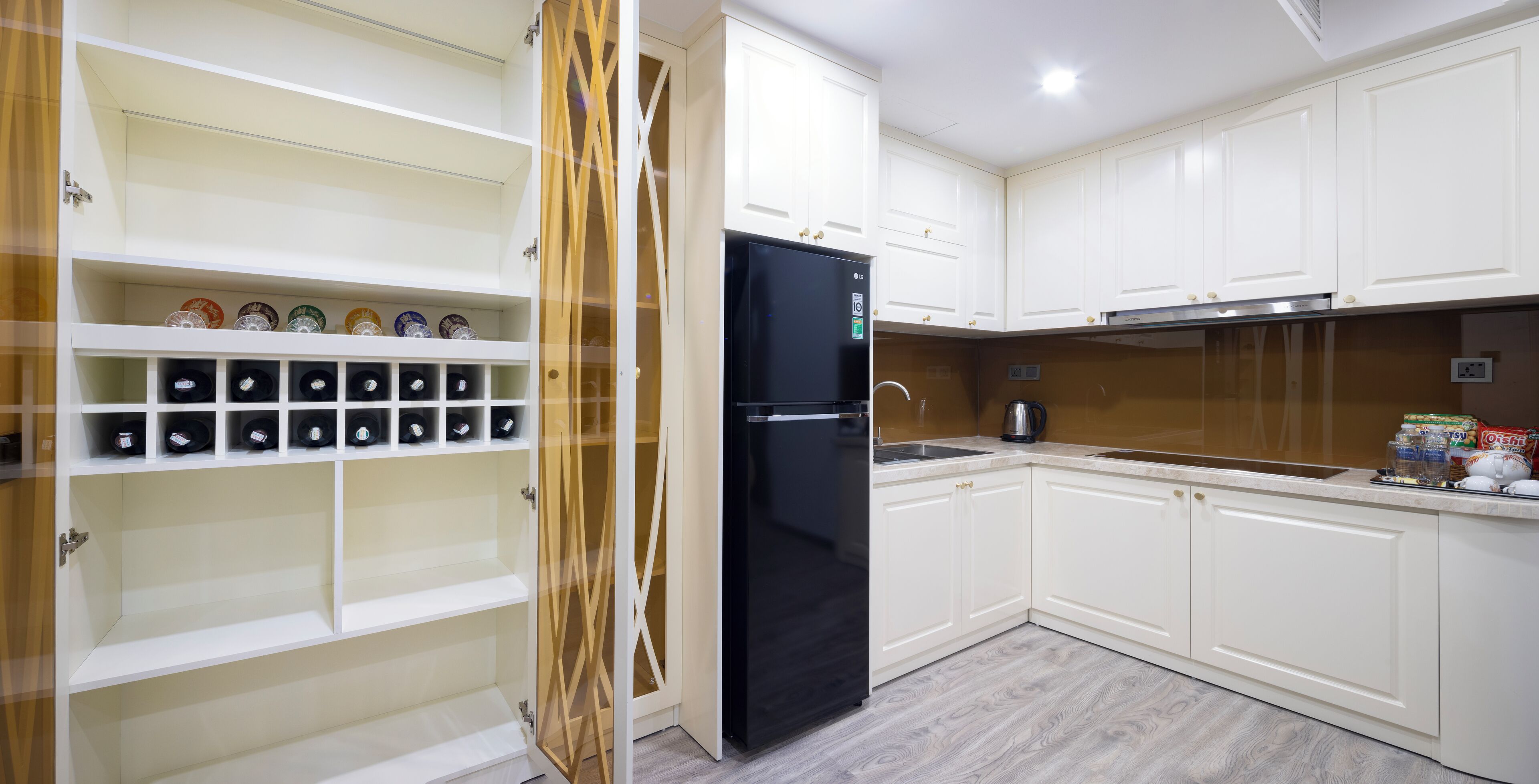 A modern kitchen with white cabinetry, a black refrigerator, and a built-in oven.