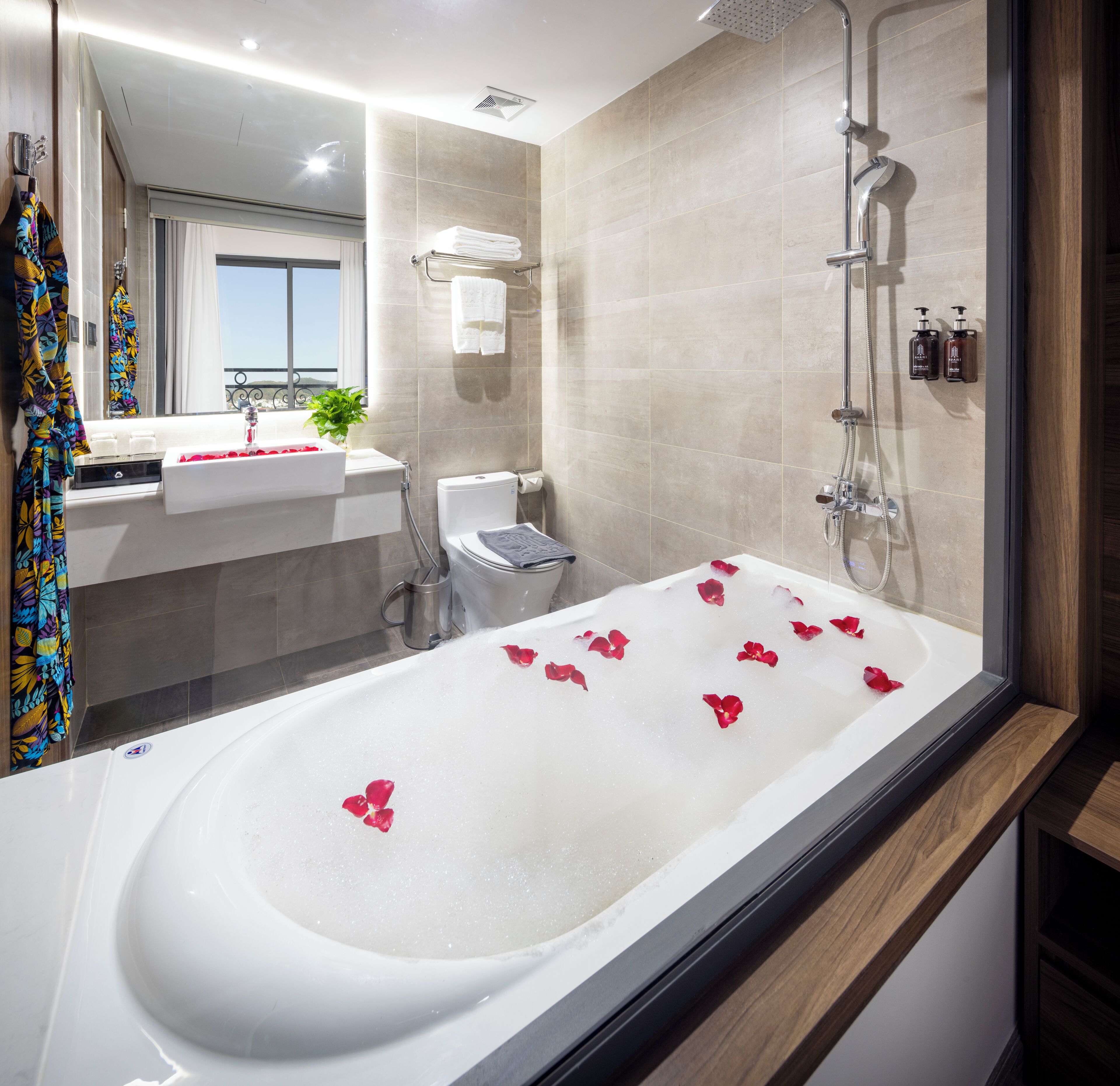 A modern bathroom with a bathtub, shower, and toilet.