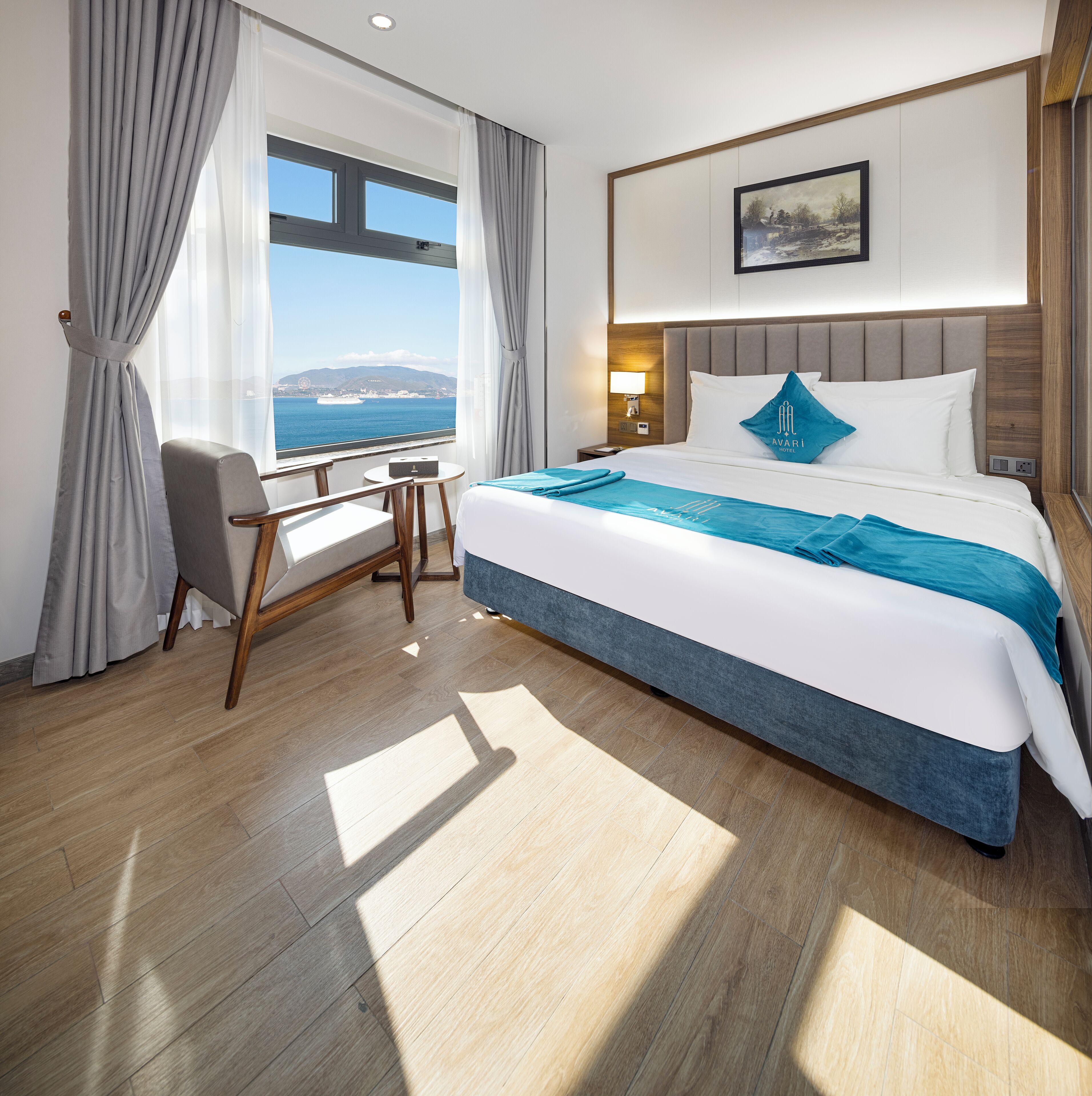 Une chambre d’hôtel avec un grand lit, un bureau et une vue sur la mer.